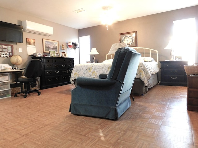 bedroom with light parquet flooring and an AC wall unit