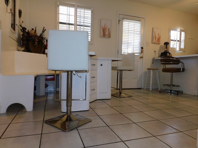 kitchen with white cabinets, tile patterned floors, and a breakfast bar area