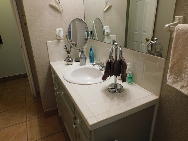 bathroom featuring tile patterned floors, vanity, and tasteful backsplash