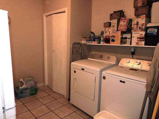 washroom with light tile patterned floors and washer and clothes dryer