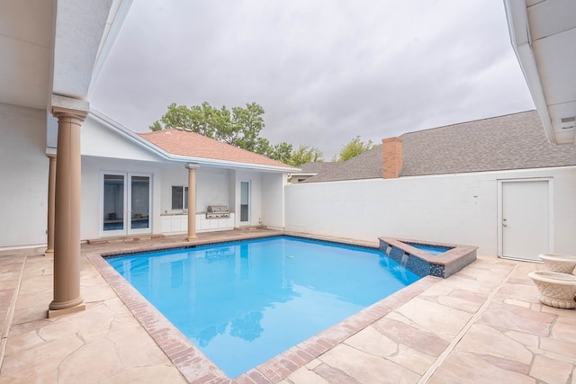 view of pool with a patio area and an in ground hot tub