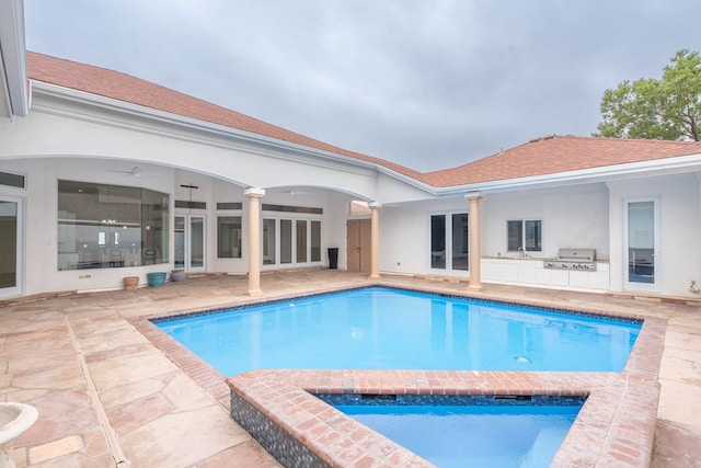 view of pool with a patio, area for grilling, and exterior kitchen