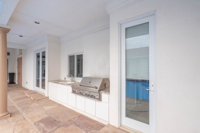 view of patio / terrace with french doors, an outdoor kitchen, area for grilling, and sink