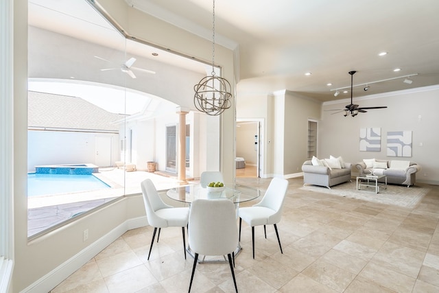 dining space featuring decorative columns, crown molding, and ceiling fan with notable chandelier