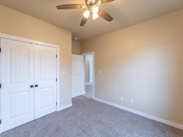 unfurnished bedroom featuring a ceiling fan, carpet, a closet, and baseboards