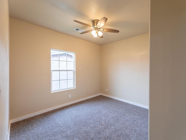 empty room with ceiling fan, carpet, visible vents, and baseboards