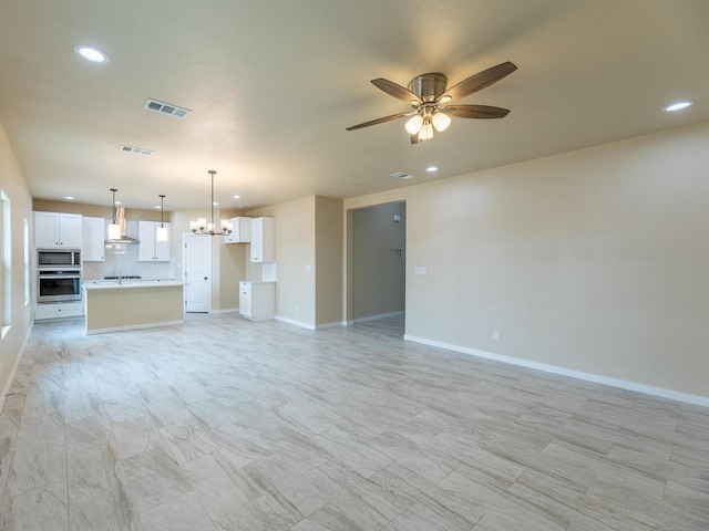 unfurnished living room with baseboards, visible vents, and ceiling fan with notable chandelier