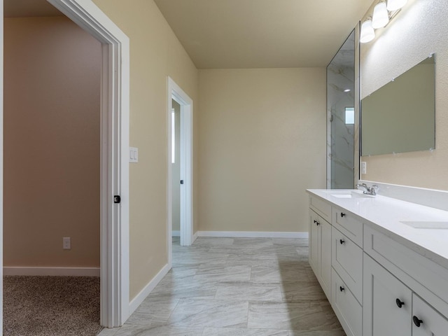 bathroom featuring double vanity, a sink, and baseboards