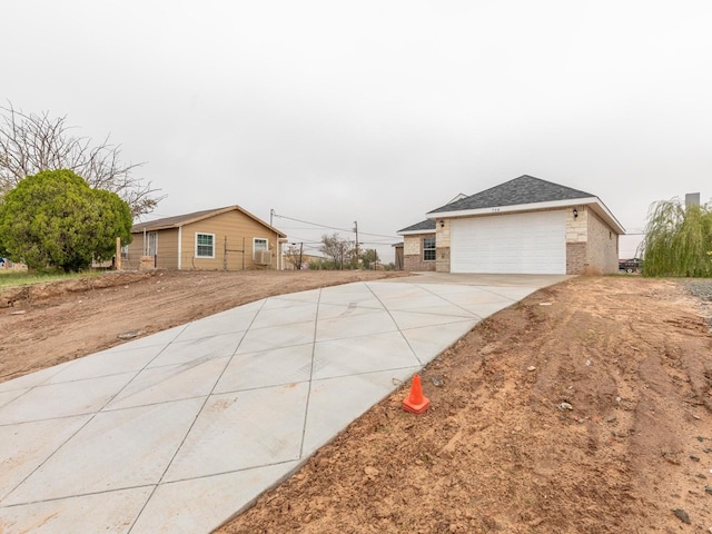 exterior space featuring a garage, brick siding, and driveway