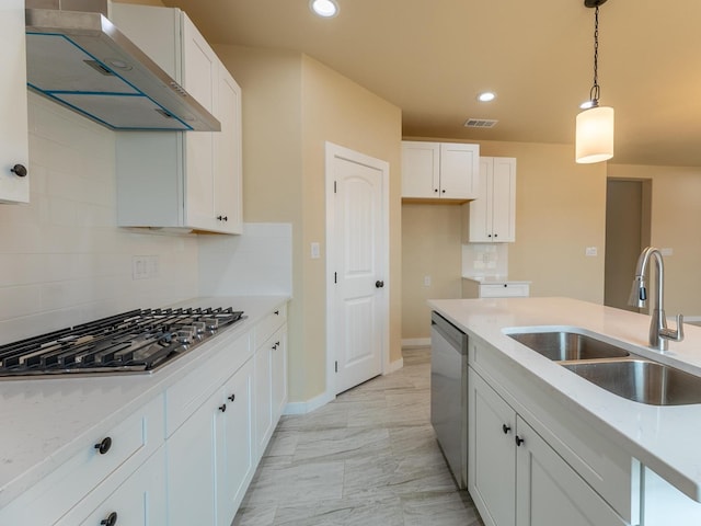 kitchen with under cabinet range hood, a sink, white cabinetry, appliances with stainless steel finishes, and pendant lighting