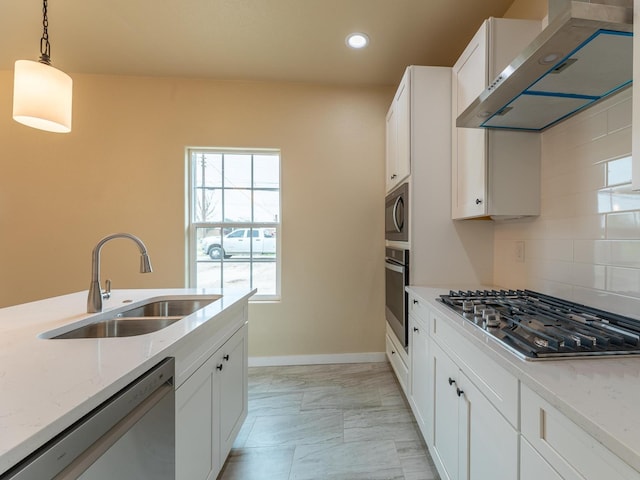 kitchen with light stone counters, a sink, appliances with stainless steel finishes, ventilation hood, and decorative backsplash