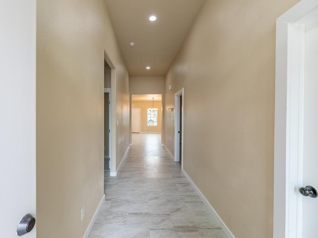 hall with recessed lighting and baseboards