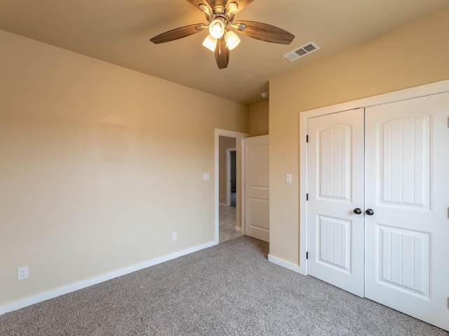 unfurnished bedroom featuring ceiling fan, carpet flooring, visible vents, baseboards, and a closet