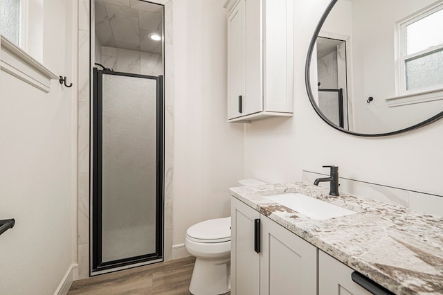 bathroom featuring vanity, toilet, an enclosed shower, and hardwood / wood-style floors