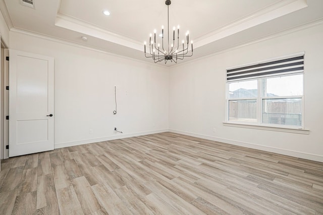 unfurnished room with a chandelier, ornamental molding, a raised ceiling, and light wood-type flooring