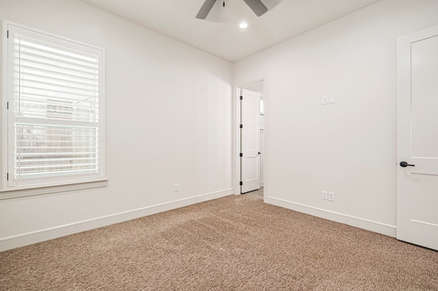 carpeted spare room with ceiling fan