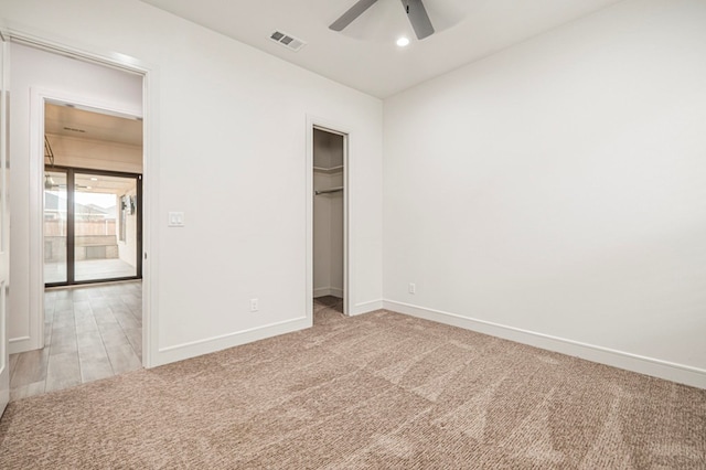 unfurnished bedroom with ceiling fan, a closet, and light carpet