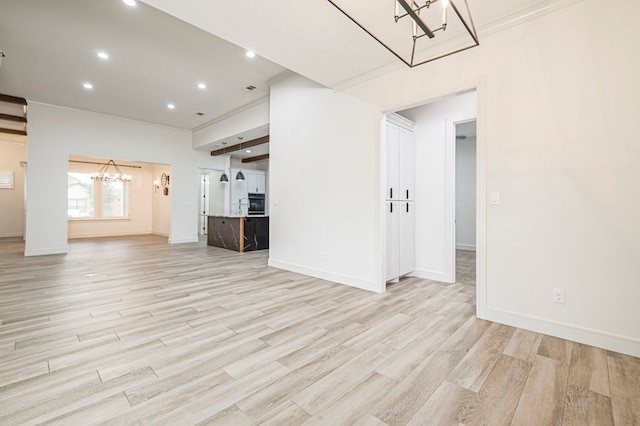 unfurnished living room featuring a notable chandelier and light wood-type flooring