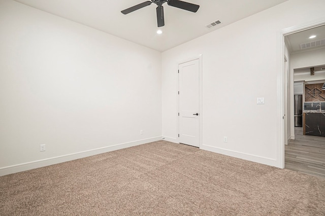 empty room featuring ceiling fan and carpet flooring