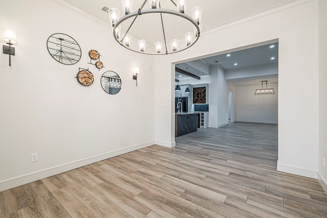 unfurnished dining area with ornamental molding, wood-type flooring, and a notable chandelier