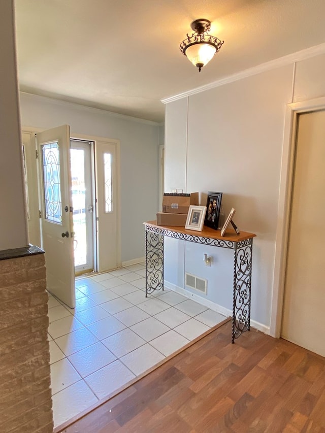 kitchen featuring crown molding, white cabinets, and light hardwood / wood-style floors