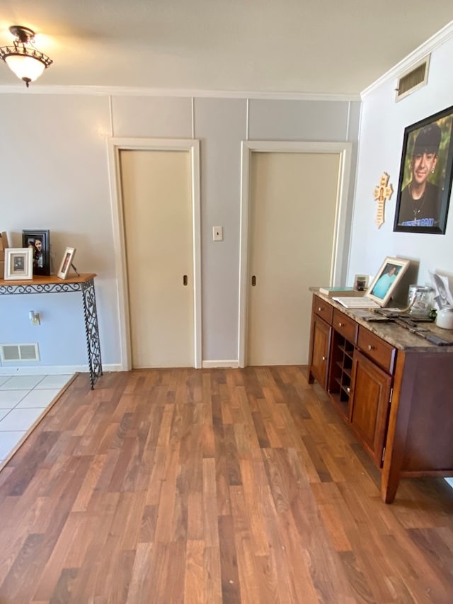 foyer with hardwood / wood-style flooring and ornamental molding