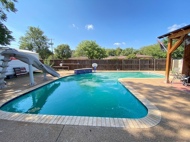 view of pool featuring a patio area and a water slide