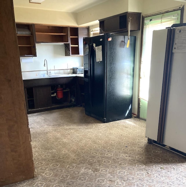 kitchen featuring fridge, plenty of natural light, and black refrigerator with ice dispenser