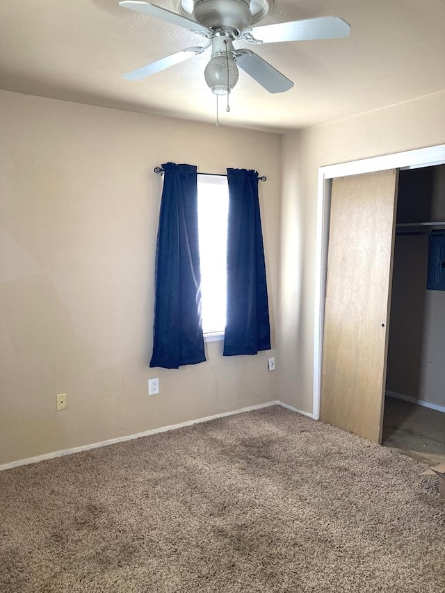 unfurnished bedroom featuring carpet floors, a closet, and ceiling fan