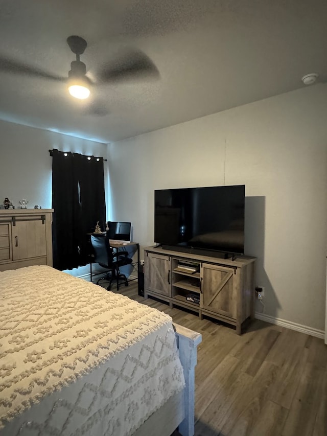 bedroom featuring hardwood / wood-style floors, a textured ceiling, and ceiling fan