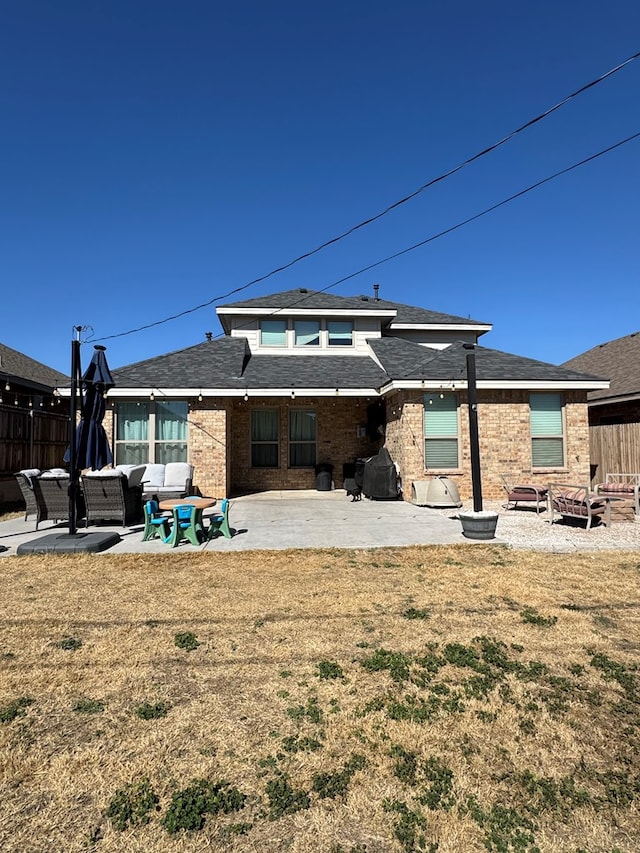 rear view of property with a patio, an outdoor living space with a fire pit, and a lawn