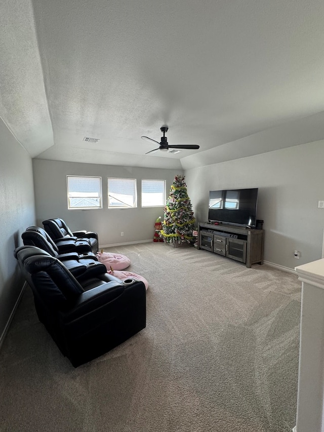 carpeted living room featuring ceiling fan and a textured ceiling