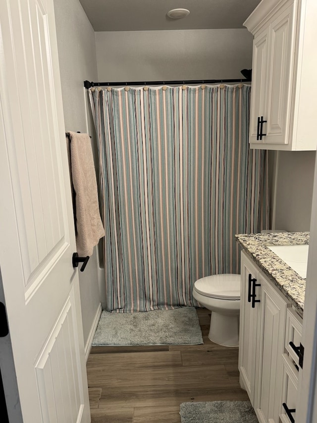 full bathroom with vanity, hardwood / wood-style floors, shower / bath combination with curtain, and toilet