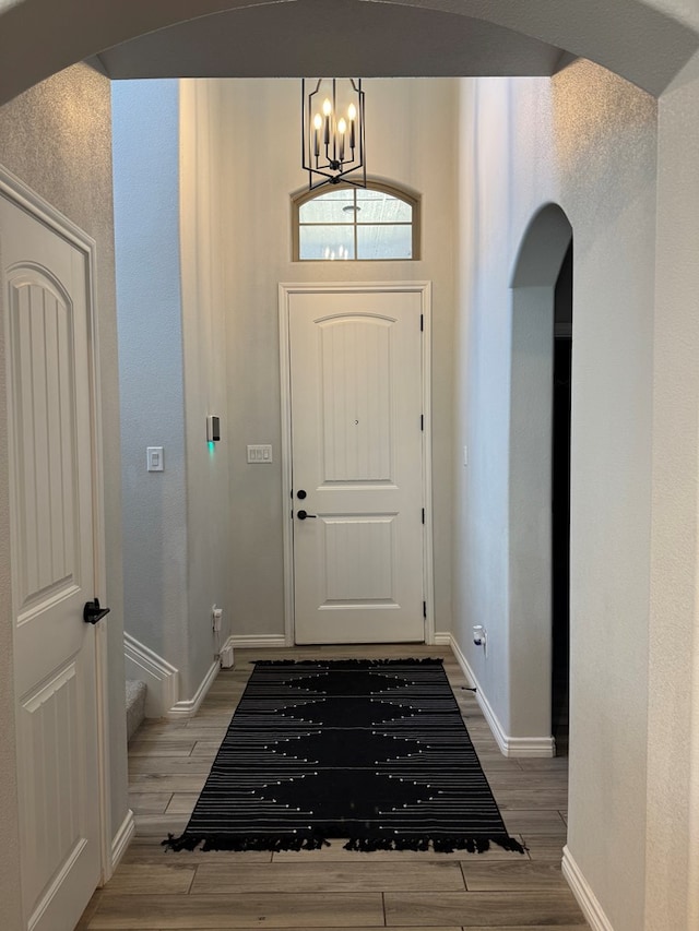 foyer entrance with wood-type flooring and a chandelier