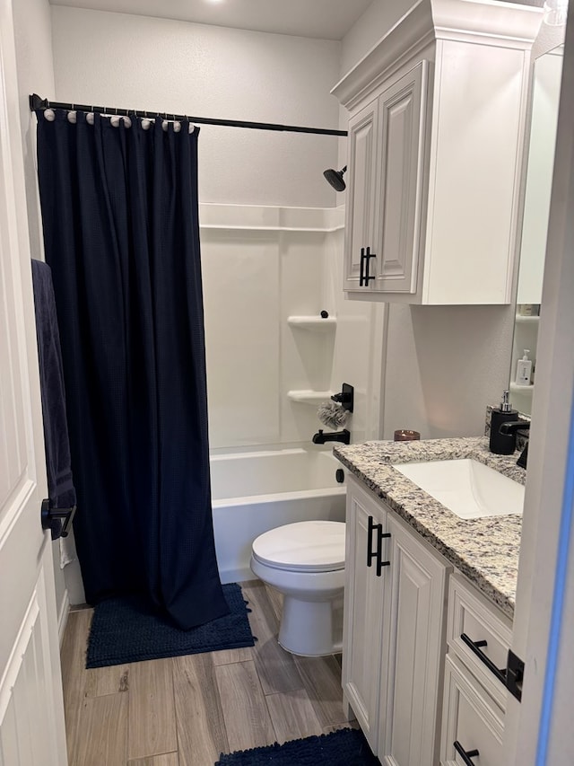 full bathroom with hardwood / wood-style flooring, vanity, shower / tub combo with curtain, and toilet