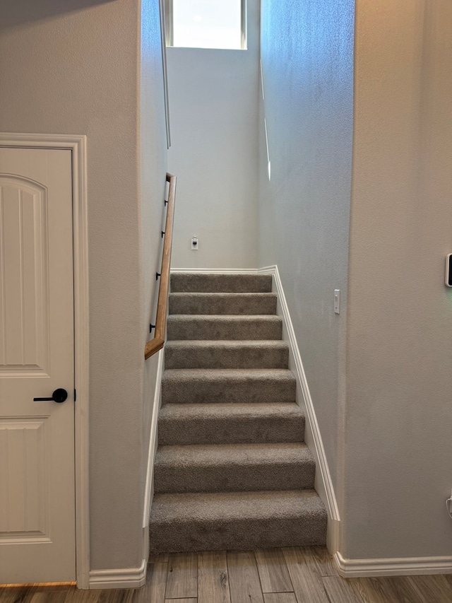 staircase with hardwood / wood-style floors