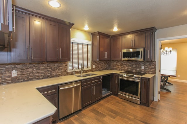 kitchen featuring dark hardwood / wood-style flooring, sink, a textured ceiling, and appliances with stainless steel finishes