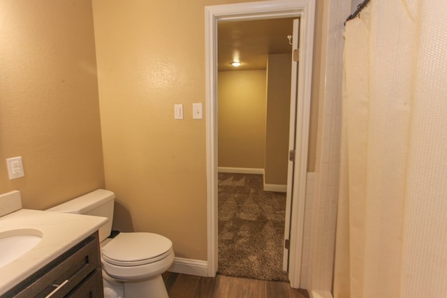 bathroom featuring vanity, wood-type flooring, and toilet