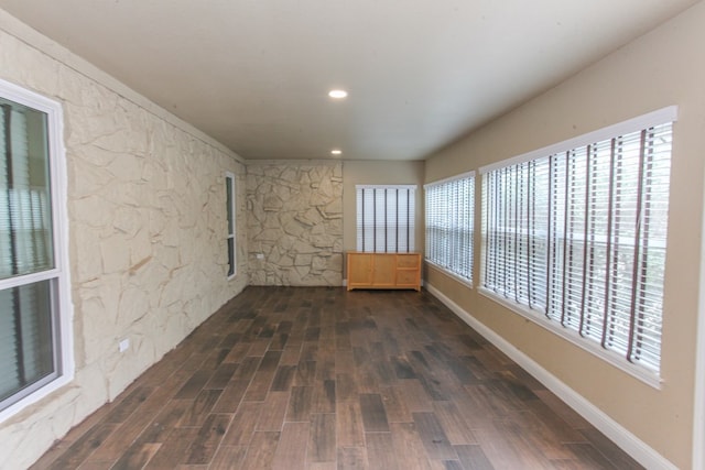 spare room with a healthy amount of sunlight and dark hardwood / wood-style flooring