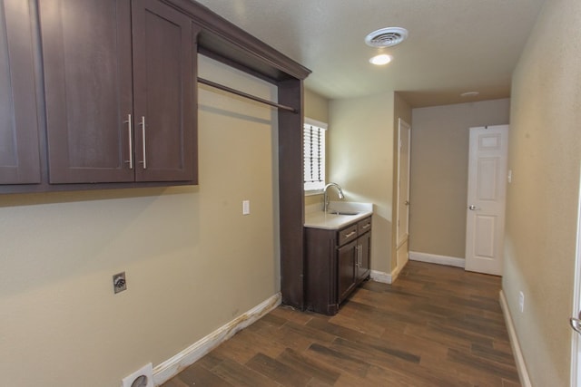 laundry room with cabinets, dark hardwood / wood-style floors, electric dryer hookup, and sink