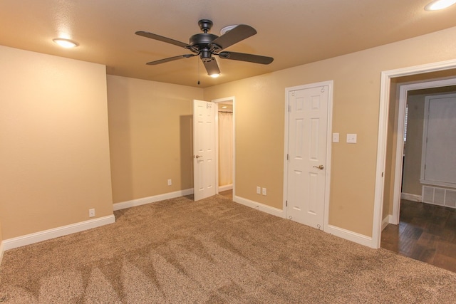 unfurnished bedroom featuring dark colored carpet and ceiling fan