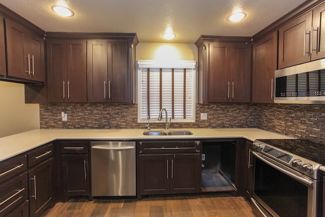 kitchen featuring a textured ceiling, stainless steel appliances, hardwood / wood-style flooring, and sink