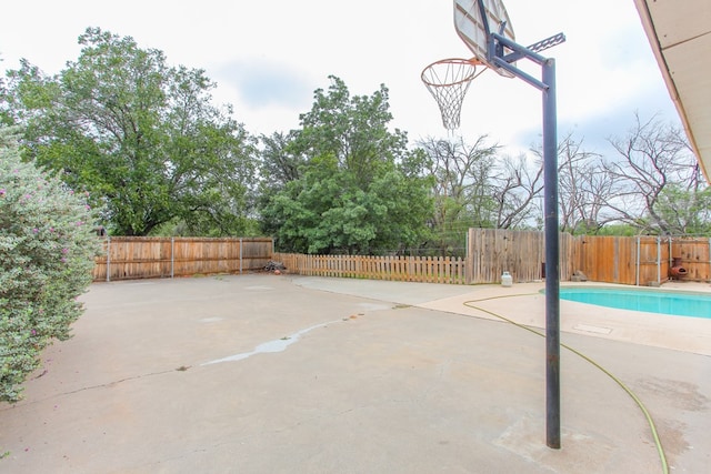 view of basketball court with a fenced in pool