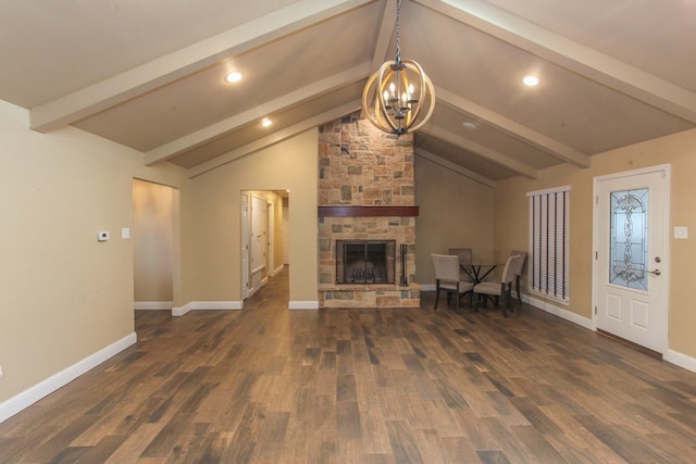 unfurnished living room featuring vaulted ceiling with beams, dark hardwood / wood-style floors, a stone fireplace, and a notable chandelier