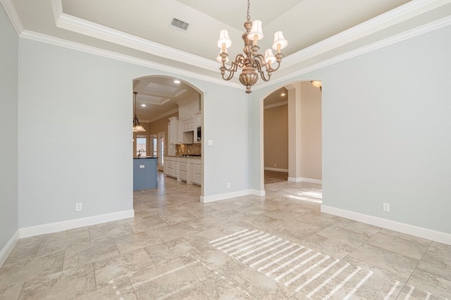 unfurnished room featuring a notable chandelier, a tray ceiling, and ornamental molding