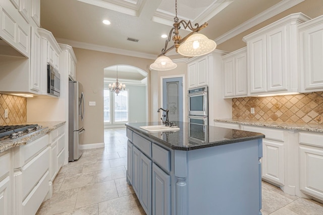 kitchen with appliances with stainless steel finishes, sink, a center island with sink, and white cabinets