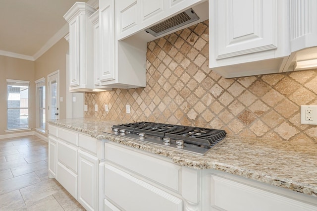 kitchen with white cabinetry, decorative backsplash, ornamental molding, stainless steel gas cooktop, and light stone countertops