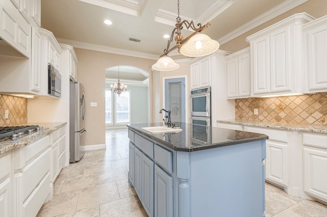 kitchen featuring a kitchen island with sink, sink, and white cabinets