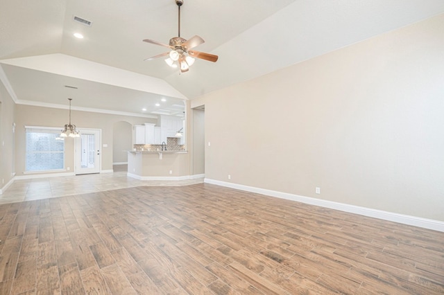 unfurnished living room with crown molding, lofted ceiling, ceiling fan, and light hardwood / wood-style flooring