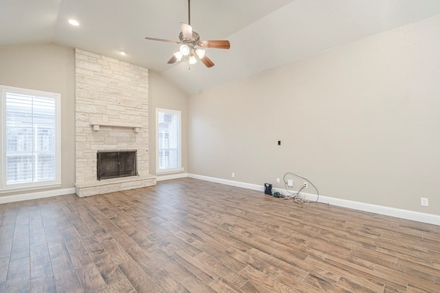 unfurnished living room featuring hardwood / wood-style floors, vaulted ceiling, a fireplace, and ceiling fan